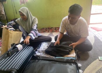 MUHAMMAD Syahmi Azril Saidijamal dibantu ibunya, Nor Azlinda Ahmad mengemas pakaian dan barangan yang perlu dibawa untuk menyambung pengajian ketika ditemui di rumahnya di Bandar Baru Beris Jaya, Sik, Kedah hari ini.