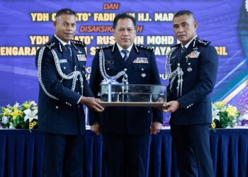RUSDI Mohd. Isa (tengah) menyaksikan serah terima tugas di antara Mohamed Usuf (kiri) dan Fadil di IPK Kuala Lumpur hari ini.