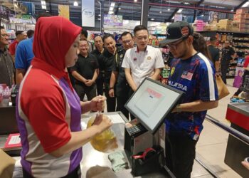 LEE Ting Han (dua dari kanan) melihat pelanggan membeli minyak masak di tempat bayaran di Pasaraya Maslee B5, Johor Bahru, Johor. UTUSAN/BAAZLAN IBRAHIM