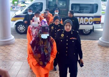 KESEMUA suspek diiringi Pegawai SPRM bagi mendapatkan permohonan reman di Mahkamah Ayer Keroh Melaka hari ini.-UTUSAN/ARIF HAMIZAN MISKON