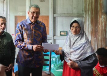 WAN Ahmad Dahlan Abdul Aziz (dua, kiri) menyerahkan sumbangan kepada Siti Rubiah Mohammad balu kepada Allahyarham Kamal Ariffin di Taman Sabariah, Pengkalan Chepa, Kota Bharu, Kelantan hari ini. - UTUSAN/KAMARUL BISMI KAMARUZAMAN