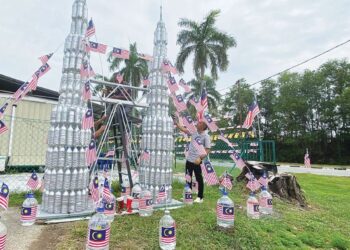 REPLIKA Menara Berkembar Petronas yang dihasilkan daripada barangan terpakai berjaya menyemarakkan semangat kemerdekaan dalam kalangan warga Rukun Tetangga (KRT) Taman Pinggiran Senawang, Seremban. – UTUSAN/NOR SHAFAWATI YUP