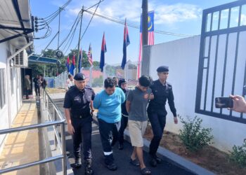 MOHAMMAD Syafiq Azmi (kiri) dan Awie Serah dibawa keluar dari Mahkamah Sesyen, Kluang, Johor selepas mengaku bersalah menjadi keldai akaun.