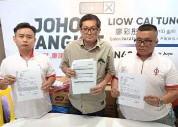ONG (tengah) menunjukkan laporan bank dan laporan polis dalam sidang akhbar di Pejabat ADUN Johor Jaya, Johor Bahru, Johor.