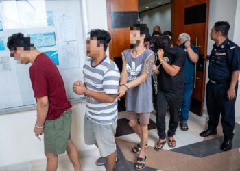 ANGGOTA polis membawa sembilan individu yang dituduh berhubung sindiket penyeludupan migran warga Myanmar di Mahkamah Majistret, Klang. - UTUSAN/SADDAM YUSOFF
