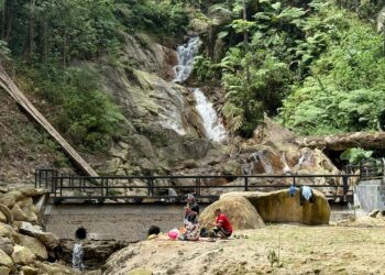 PENGUNJUNG tidak melepaskan peluang untuk berkelah bersama keluarga pada hari pertama pembukaan semula Taman Eko Rimba Jeram Toi di Jelebu hari ini. - UTUSAN/NOR SHAFIQAH MOHD. GHAZALI