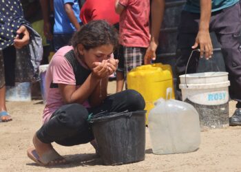 SEORANG kanak-kanak perempuan minum air dari baldi plastik ketika cuaca panas terik di kawasan Al-Mawasi di Khan Younis, selatan Gaza. – AFP
