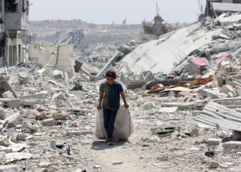 KANAK-KANAK Palestin mengangkut barangan yang dapat diselamatkan berhampiran bangunan musnah di kejiranan
al-Tuffah, Bandar Gaza. – AFP