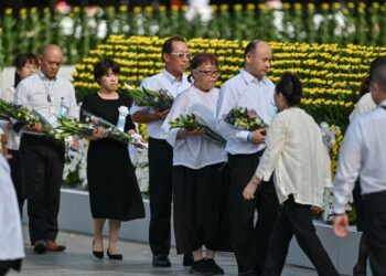 TETAMU jemputan beratur untuk meletakkan jambangan bunga di Tugu Cenotaph, semasa Majlis Memorial Keamanan untuk memperingati ulang tahun ke-80 serangan bom atom pertama dunia di Hiroshima, semalam.- AFP