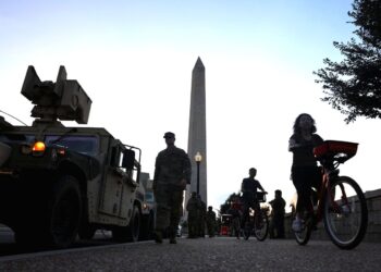 PELANCONG berbasikal melalui kenderaan Pengawal Kebangsaan berhampiran Monumen Washington pada Selasa lalu. – AGENSI