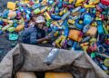 SEORANG remaja lelaki Afghanistan mengasingkan botol plastik yang boleh dikitar semula di Kabul. – AFP