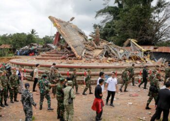 ATASE tentera dan diplomat dari 13 negara memerhati pelaksanaan perjanjian gencatan senjata antara Kemboja-Thailand, di sebelah bangunan yang musnah berhampiran pusat pemeriksaan sempadan An Ses, wilayah Preah Vihear, Rabu lalu.- AFP