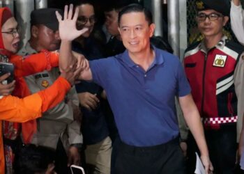 BEKAS Menteri Perdagangan Indonesia, Tom Lembong (tengah) melambai tangan ke arah media ketika meninggalkan Penjara Cipinang di Jakarta, kelmarin.- AGENSI