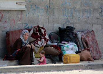 SEORANG wanita bersama anaknya duduk di sebelah barangan mereka untuk berpindah ke utara Gaza City. – AFP