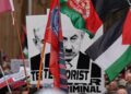 PENUNJUK perasaan memegang sepanduk imej Perdana Menteri Israel, Benjamin Netanyahu, semasa perhimpunan pro-Palestin di Sydney, Australia, pada 3 Ogos lalu.- AFP