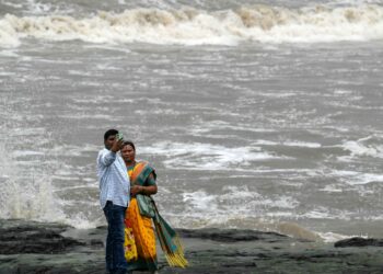 SATU pasangan mengambil gambar swafoto di pantai di Mumbai, India. – AFP
