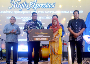 AB. Rauf Yusoh menyampaikan cek bernilai RM53,900 kepada Pengarah JPN Melaka, Mahfudzah Mohamed Noor pada Majlis Apresiasi Pelajar Cemerlang STPM, Bijak Sejarah STPM, STAM dan Pelajar Huffaz 2024 di MITC, Ayer Keroh, Melaka. - UTUSAN/AMRAN MULUP
