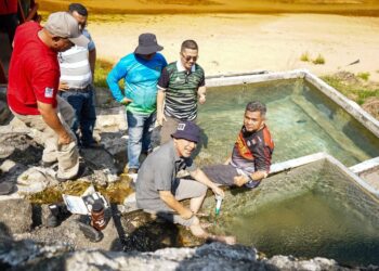 RAZALI Idris (duduk, tengah) ketika melawat Cek Mek Hot Spring di kawasan Ladang Cenderung Putera North, Ban Hol, Cerul, Kemaman, Terengganu.