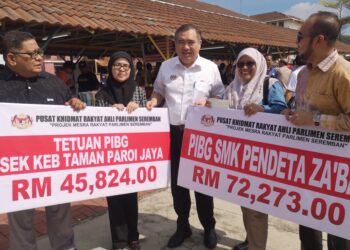 ANTHONY LOKE (tengah) bersama wakil penerima sekolah selepas Majlis Penyerahan Cek Peruntukan Parlimen Seremban di Sekolah Kebangsaan Sikamat, di sini hari ini. - UTUSAN /NUR SHARIEZA ISMAIL