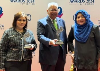 Ir Guntor Tobeng  bersama Pengarah Eksekutif Gading Kencana Sdn. Bhd., Datin Hasnah Awang (kanan) menunjukkan Anugerah Merdeka Credit Guarantee Corporation Malaysia Bhd (CGC) di Kuala Lumpur, baru-baru ini.