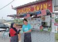 MUHAMMAD Rizwan Tiu Abdullah  dan isterinya, Nur Faizan di gerai jualan burger diusahakan mereka di Taman Sri Intan di Gemencheh, Tampin, Negeri Sembilan. – UTUSAN/NOR AINNA HAMZAH