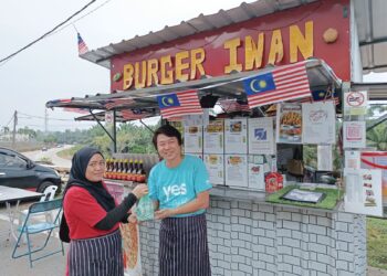 MUHAMMAD Rizwan Tiu Abdullah  dan isterinya, Nur Faizan di gerai jualan burger diusahakan mereka di Taman Sri Intan di Gemencheh, Tampin, Negeri Sembilan. – UTUSAN/NOR AINNA HAMZAH
