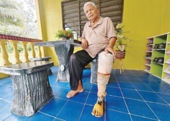 HAMIDUN Kamis menunjukkan kaki palsu yang dipakainya di rumahnya di Kampung Bapong, Lipis, Pahang semalam. –  UTUSAN/NORFARHIZA MOHD. ATAR