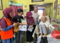 KHAIRIN-NISA Ismail (tengah) menyantuni Mat Sentol di kediaman keluarganya di Larkin, Johor Bahru, semalam.