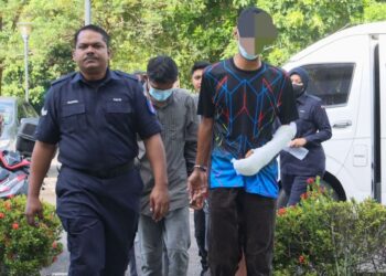 GURU lelaki (kanan) yang didakwa mengelar leher isterinya di Taman Tunas Muda, Sungai Ara, Pulau Pinang, Rabu lalu dibawa ke Mahkamah Balik Pulau, Pulau Pinang semalam.-UTUSAN/DANIAL SAAD