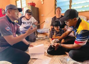 MOHD. Syahbuddin Hashim (dua dari kiri) dan Hezri Othman (kanan) bersama kakitangan Jabatan Pendaftaran Negara melakukan proses penukaran Mykad Mastaliza Mulian di Kampung Bihai Lama, Pos Bihai, Gua Musang, Kelantan, semalam. – UTUSAN/AIMUNI TUAN LAH