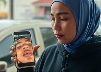RIFKA Amelia Bustomi Sofia  menunjukkan gambar anaknya yang mengalami kecederaan serius dipercayai dibuli dan diserang sekumpulan rakan sekolahnya di Kuala Terengganu, Terengganu. - UTUSAN/PUQTRA HAIRRY