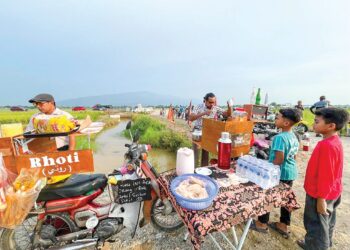 HAFIZ Ahmad (kanan) bersama rakannya di lokasi santai tengah sawah dengan suasana 70-an di Kampung Kepala 10, Ulu Sedaka di Yan, Kedah.