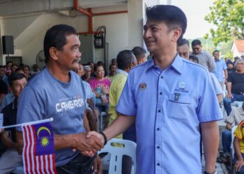 MUHAMMAD Faiz Fadzil (kanan) bersalaman dan beramah mesra dengan nelayan pada Program Rahmah Mesra Madani bersama nelayan Pulau Pinang di Kompleks Pendaratan Ikan Jelutong, George Town, Pulau Pinang, hari ini.-UTUSAN/DANIAL SAAD