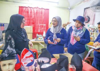 SHARMILA Mohamed Salleh (tengah) melihat pembuatan tanjak dan tengkolok dihasilkan oleh Jalwani Fairuz Abd. Razak di Kampung Telaga Tengah, Mukim Gunong di Alor Setar, semalam. – UTUSAN/ SHAHIR NOORDIN