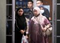 EDA Ezrin (kiri) bersama ibunya selepas selesai memberi keterangan kepada polis di Balai Rantau Panjang, Kelantan sebentar tadi-UTUSAN/KAMARUL BISMI KAMARUZAMAN