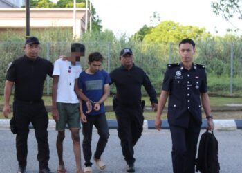 ANGGOTA polis mengiringi tertuduh
(tengah) untuk prosiding perbicaraan di Mahkamah Sesyen Kota Bharu, Kelantan hari ini-UTUSAN/ROSALWANI CHE SOH.