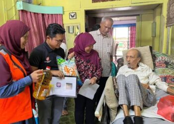 KHAIRIN-NISA Ismail (tengah) menyantuni Mat Sentol di kediaman keluarganya di Larkin, Johor Bahru, hari ini.