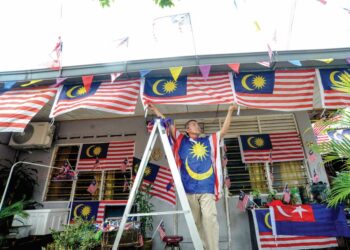 AWANG Sebawi  Awg Halil memasang Jalur Gemilang bagi menyemarakkan lagi sambutan hari Kebangsaan di rumahnya di Taman Desa Rahmat, Johor Bahru. – UTUSAN/RAJA JAAFAR ALI