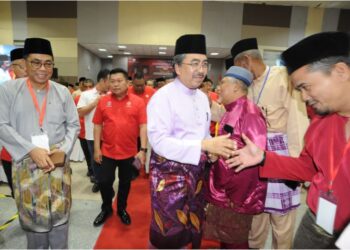 JOHARI Abdul Ghani diiringi Mohamed Khaled Nordin bersalaman dengan perwakilan yang hadir sempena  Mesyuarat Perwakilan UMNO Bahagian Pasir Gudang di Dewan Muafakat Taman Mawar, Pasir Gudang, hari ini. - UTUSAN/RAJA JAAFAR ALI