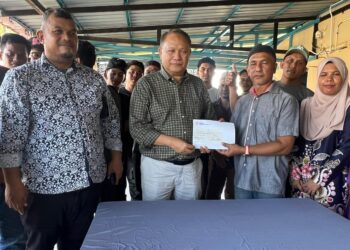 MOHD. Zaki Md. Nor (dua dari kanan) menerima sumbangan daripada Mohamad Mohyddin Mohamed Nor di Kampung Telaga Papan, Pasir Puteh, Kelantan. – UTUSAN/TOREK SULONG