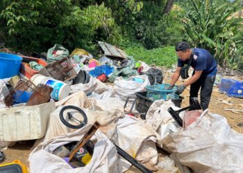 WAN Azli Wan Abdullah mengasingkan barangan kitar semula yang dijumpai di tapak pelupusan sampah sementara MDGM di Kampung Kundur, Gua Musang, Kelantan. – UTUSAN/AIMUNI TUAN LAH.