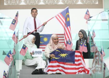 ANAK muda di sebuah pusat pengajian tinggi mengibar Jalur Gemilang sempena sambutan Bulan Kebangsaan di Arau, Perlis semalam. 
– UTUSAN/IZLIZAN OTHMA