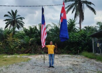 SUPAAT Abd. Rahman mengibarkan Jalur Gemilang dan bendera Johor bagi menyemarakkan sambutan Hari Kebangsaan ketika ditemui di rumahnya di Kampung Parit Marjunid Darat, Benut, Pontian, Johor.