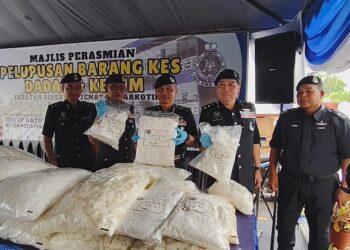 MOHAMMAD Azlin Sadari  (tengah) menunjukkan dadah yang dilupuskan pada Majlis Pelupusan Barang Kes Jabatan Siasatan Jenayah Narkotik di Ibu Pejabat Polis Kontinjen (IPK) Perak, Ipoh hari ini. - UTUSAN