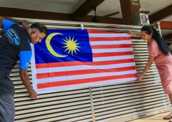 G. MANIMARAN Govindan (kiri) dan  Srirangam Nadeson memasang Jalur Gemilang di hadapan rumah mereka sempena menyambut Bulan Kemerdekaan di Taman Perumahan KP Perdana, Kubang Parit, Kuala Terengganu. - UTUSAN/PUQTRA HAIRRY