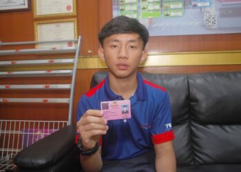 MUHAMMAD Alif Hakim Sulaiman menunjukkan kad OKU dimilikinya akibat kemalangan motosikal di jalan persisiran pantai Klebang tahun lepas. – UTUSAN/AMRAN MULUP