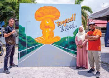 MOHAMAD Noor Haiqal Samsudin (kanan) bersama lukisan mural tragedi paip gas Putra Heights dalam Program Larian Amal di Kampung Kuala Sungai Baru, Puchong, semalam. – UTUSAN/SADDAM YUSOFF