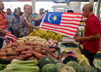 RAZALI Idris (dua dari kiri) mengagihkan Jalur Gemilang kepada peniaga semasa Majlis Agihan Bendera Malaysia sempena sambutan Hari Kemerdekaan Ke-48 di Kedai Pasar Payang, Kuala Terengganu, Terengganu. - UTUSAN/PUQTRA HAIRRY