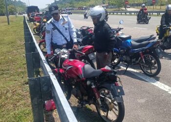 ANGGOTA polis memeriksa keadaan motosikal ditunggang Hariz Fahmi Shaizuren Amin yang maut di Lebuhraya Pantai Timur 2 (LPT2) berhampiran Bukit Besi, Terengganu. -UTUSAN/NIK NUR IZZATUL HAZWANI NIK ADNAN