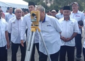 SHAMSUL Azri Abu Bakar (tengah) menggunakan peralatan menentukan arah kiblat masjid baharu selepas pelancaran Program Kampung Angkat Madani di Kampung Batu Balak di Jerantut, Pahang. - UTUSAN/HARIS FADILAH AHMAD